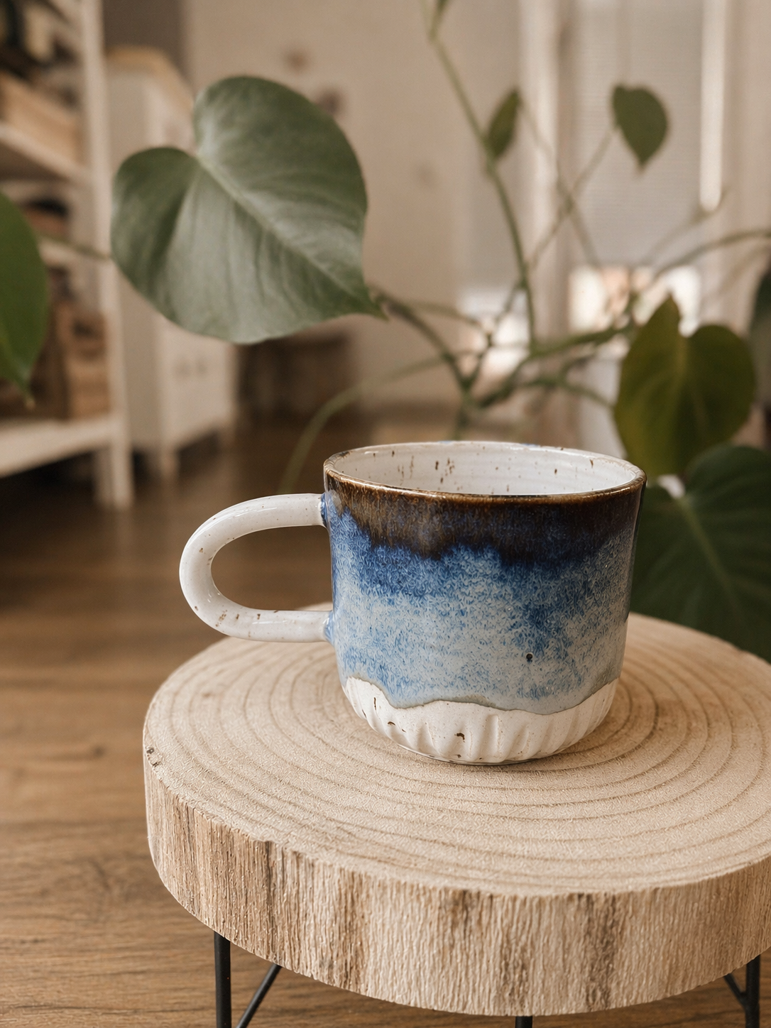 Modrý keramický šálek na dřevěné podložce doma
