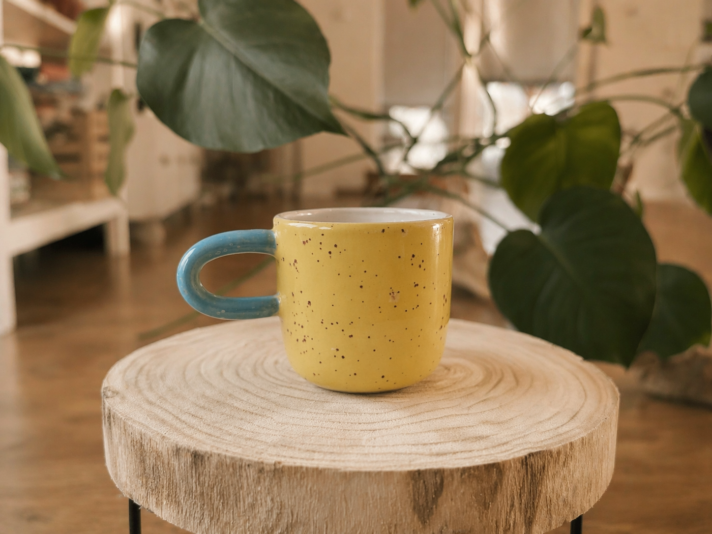 Žlutý keramický hrnek na dřevěné podložce doma